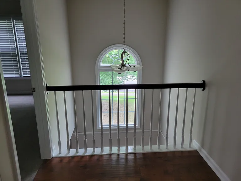 Top of the stairs looking to the left is a room for kids. That window over the railing looks out on the front lawn.