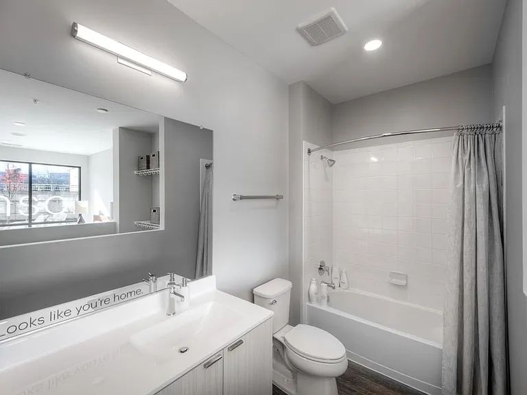 Showroom bath with white cabinetry, quartz stone countertop, and hard surface flooring