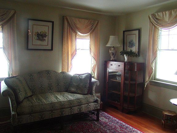 Sunny living room with decorative fireplace and wood floors