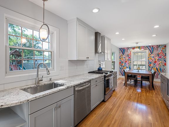 Updated galley kitchen with sink that looks out into the large, flat, fenced yard.