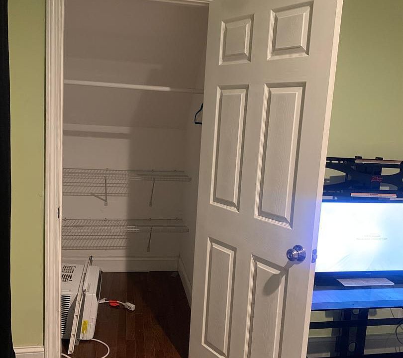 Bedroom closet with built-in shelving for organized clothing, linens, and personal storage off the sleeping area.