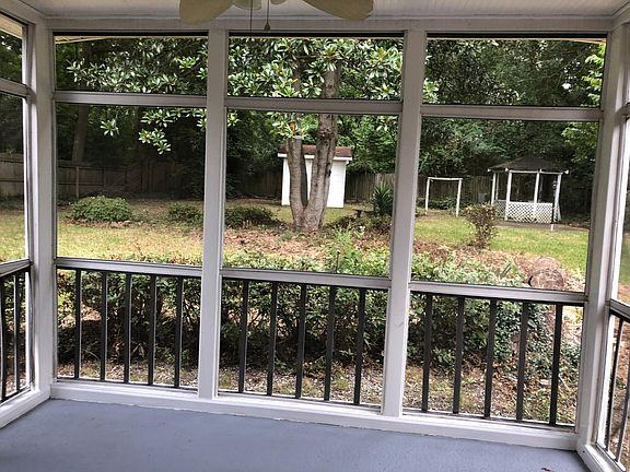 Screened in porch overlooking backyard with storage/workshop
