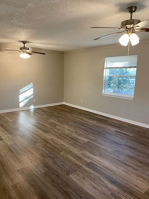 Living rooms, two ceiling fans, two windows, coat closet.