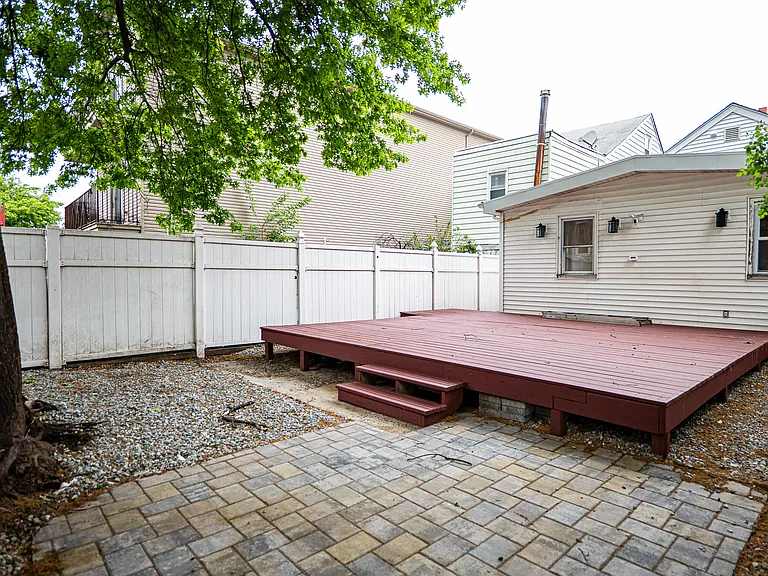 Backyard with newly painted deck. Perfect for BBQs & gatherings.