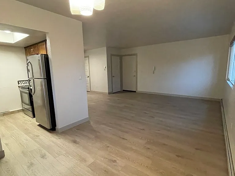 Open living area looking a front entry door and coat closet from far corner of dining room area.