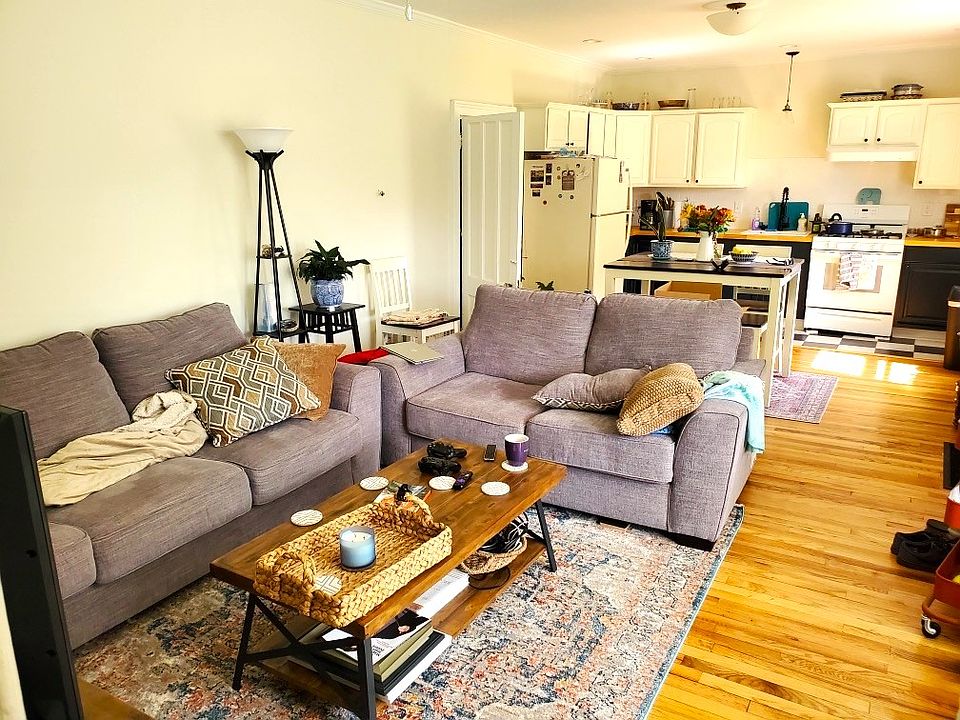 The spacious, open concept kitchen/dining/living room area has a huge floor to ceiling bay window and hardwood floors