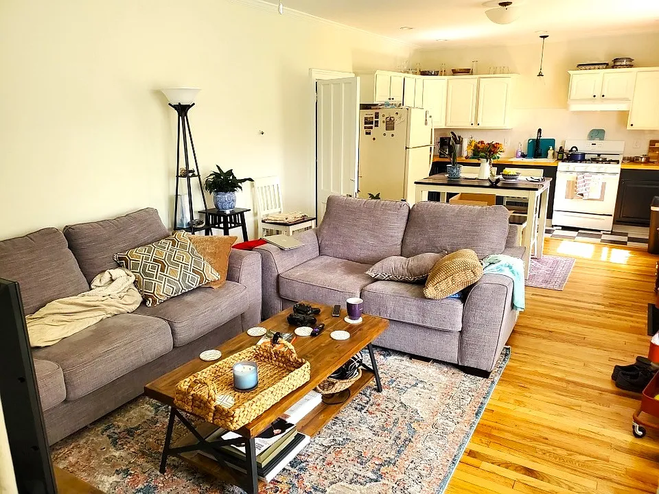 The spacious, open concept kitchen/dining/living room area has a huge floor to ceiling bay window and hardwood floors