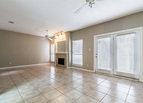 Large and open Living Room with a fireplace and ceiling fans.