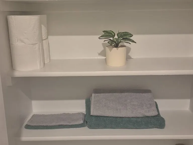 Built-in shelving provides convenient storage for toiletries, towels, and everyday essentials to keep the space organized.
