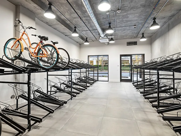 Spacious, secure indoor bike storage with double-decker racks for convenient and organized parking.