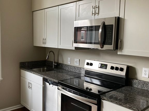 New kitchen with granite counters and stainless steel appliances