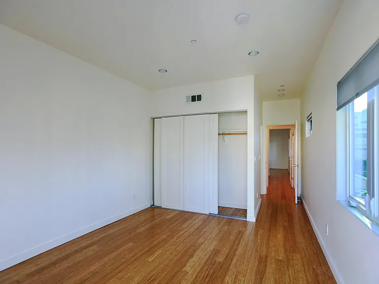 Front Bedroom Closet with Hallway Leading to Bathroom and Rear Bedroom