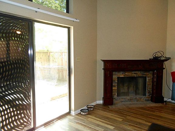 View of fireplace in den and sliding doors leading to back yard.
