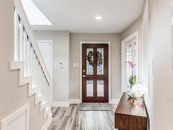 Lovely foyer that's crisp and clean, flanked by wood look tile with scraping detail, modern paint colors and natural light. The study is located on the left side of the entry as you enter the home with secondary bedrooms up.