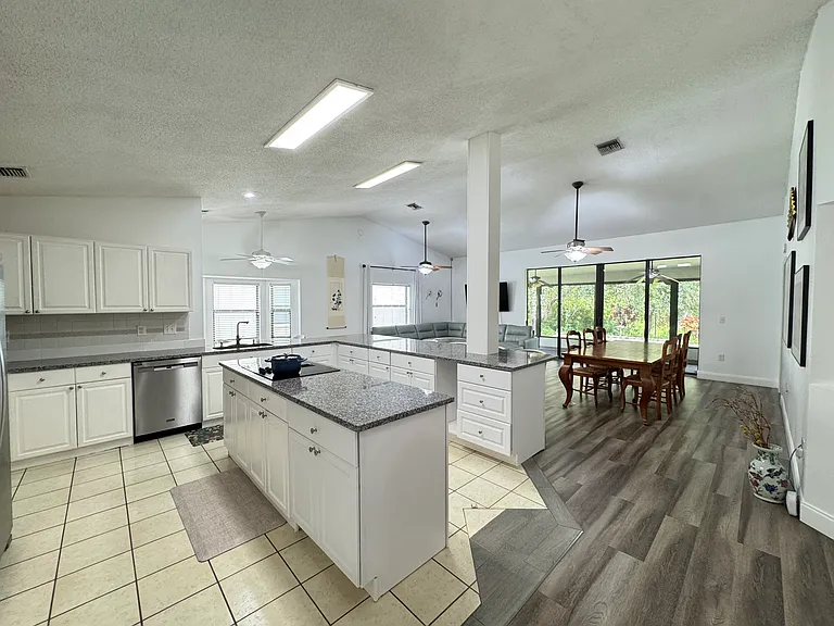 Open layout with kitchen, formal dining, gathering area and breakfast nook.