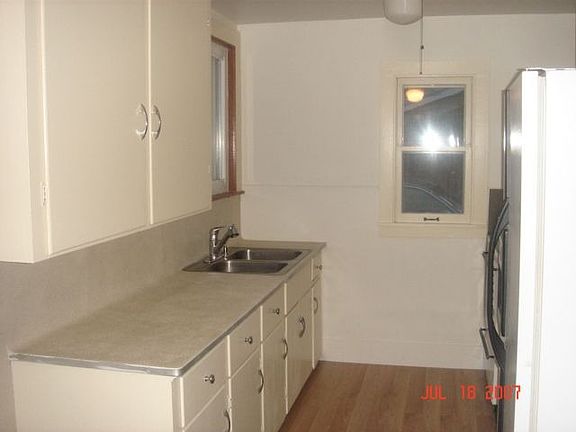 This kitchen has refinished countertops, fresh paint, and new laminate floors.