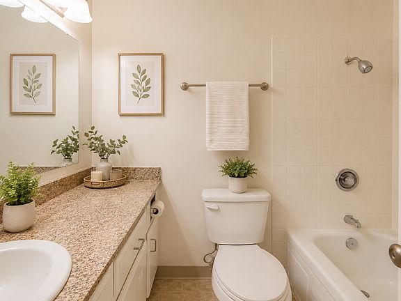 Bright bathroom featuring a large vanity, full tub/shower, and neutral finishes.