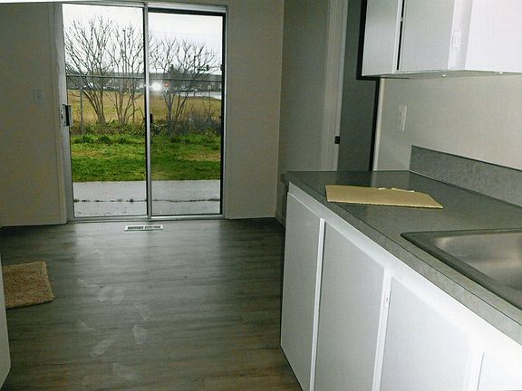 Kitchen looking to dinning and patio door and back fence yard