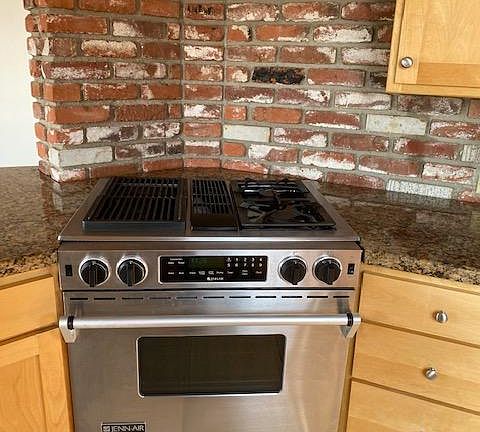 Jenn-air dual-fuel cook-top and oven with built-in downdraft fan.