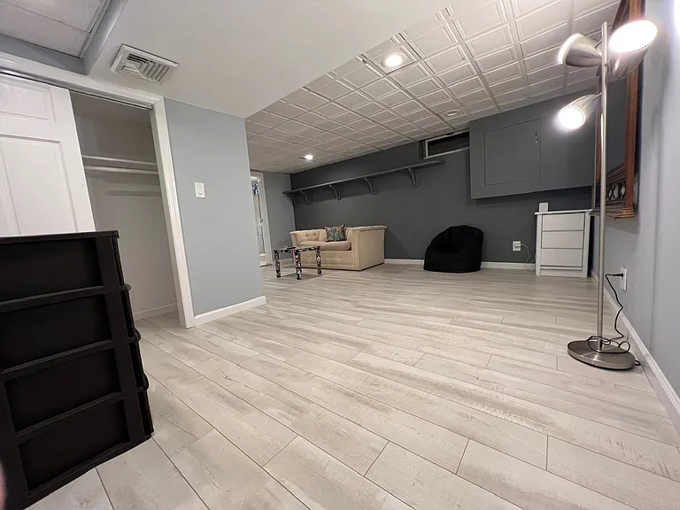 Different angle of roomy bedroom with new decorative hanging ceiling. Large closet to hand clothes.