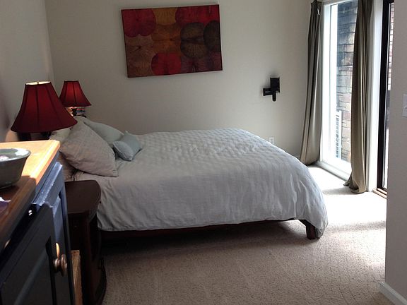 East bedroom with large walk-in closet. Sliding doors lead to patio and outdoor fireplace.