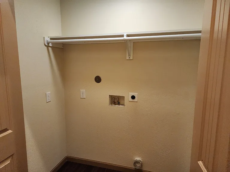 Laundry room with overhead storage.