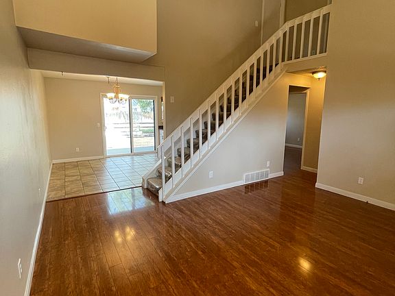 Spacious living room looking into dining room kitchen, and up to the primary suite