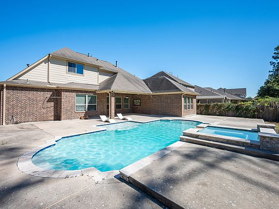 First glance of the sparkling pool, covered patio, and expansive deck area_perfect for relaxing or entertaining.