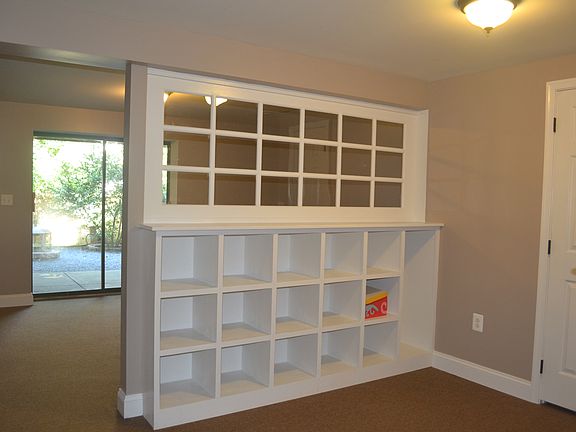 Remodeled basement featuring built-in storage leads to backyard