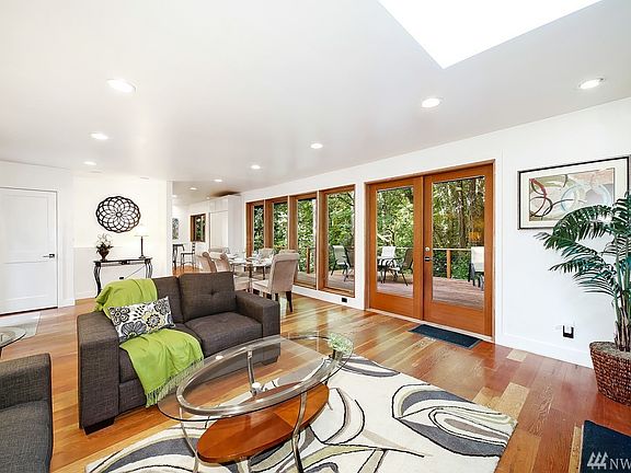 The living space with adjacent dining space look out to the back deck and lush views.