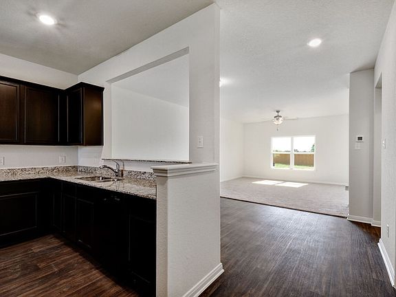 The kitchen is showcases designer wood cabinets and granite countertops.