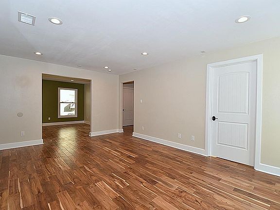 Standing in the Living Room looking towards a flexible downstairs room.  This cast opening will soon have Sliding barn doors installed. There is a full bathroom adjacent to this Flexible Room.