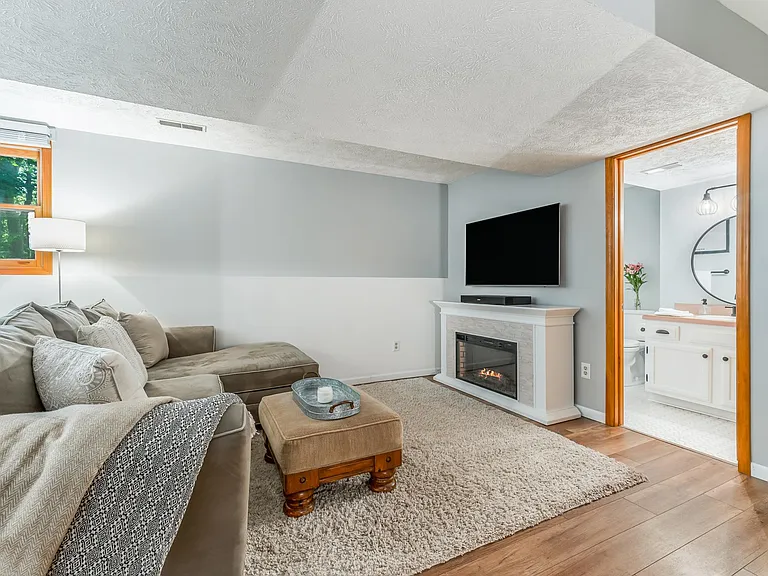 Lower level family room with electric fireplace and large 4K TV