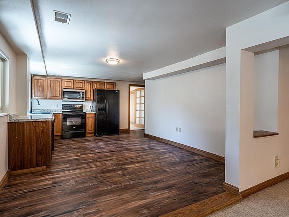 Kitchen, with windows facing East side. Entry to 3rd (non-conforming bedroom) in distance on right side of photo.
