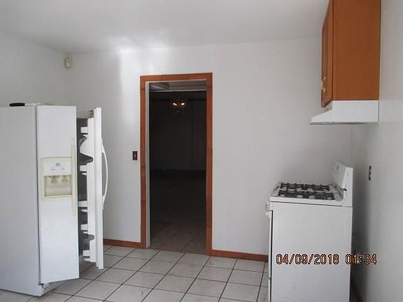 kitchen has refrigerator gas stove, ceramic tile floors. ,