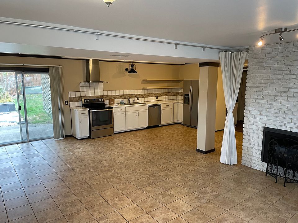 Side entrance: kitchen, main living room, gas fireplace, backyard patio.