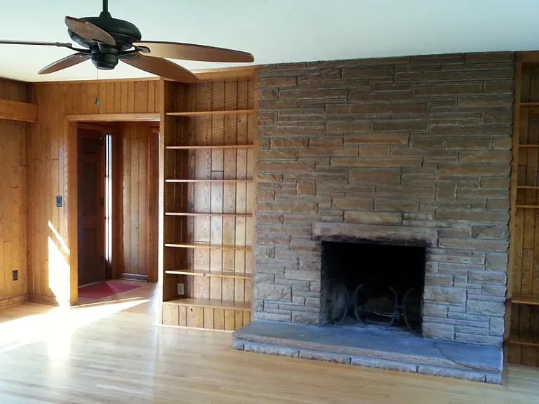 Living Room with wormy chestnut paneling and working fireplace.