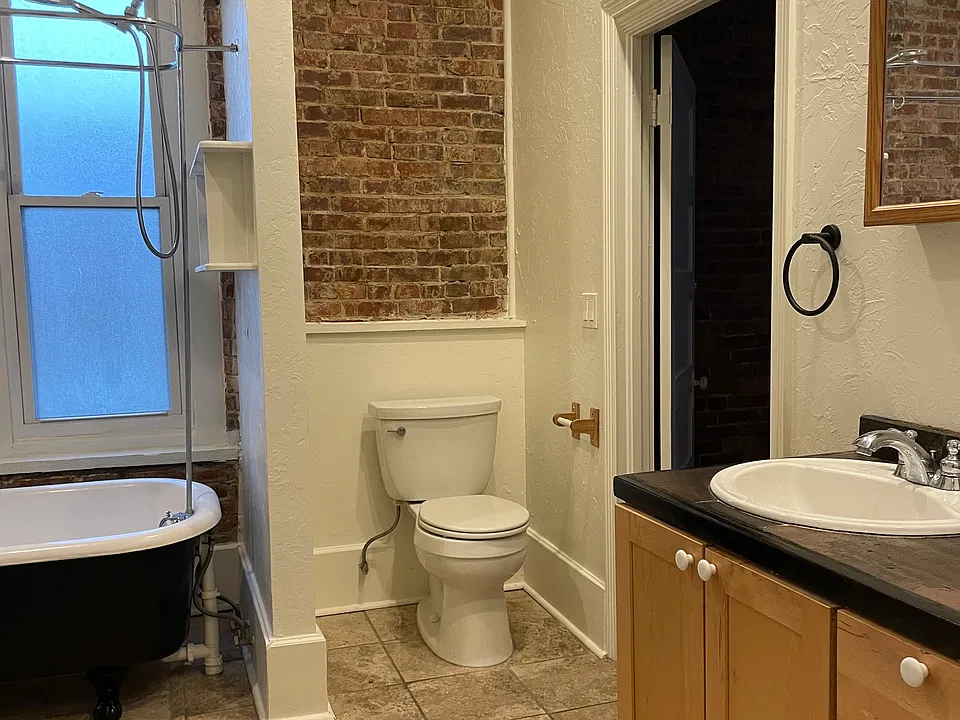 bathroom with 2 sinks and claw foot tub