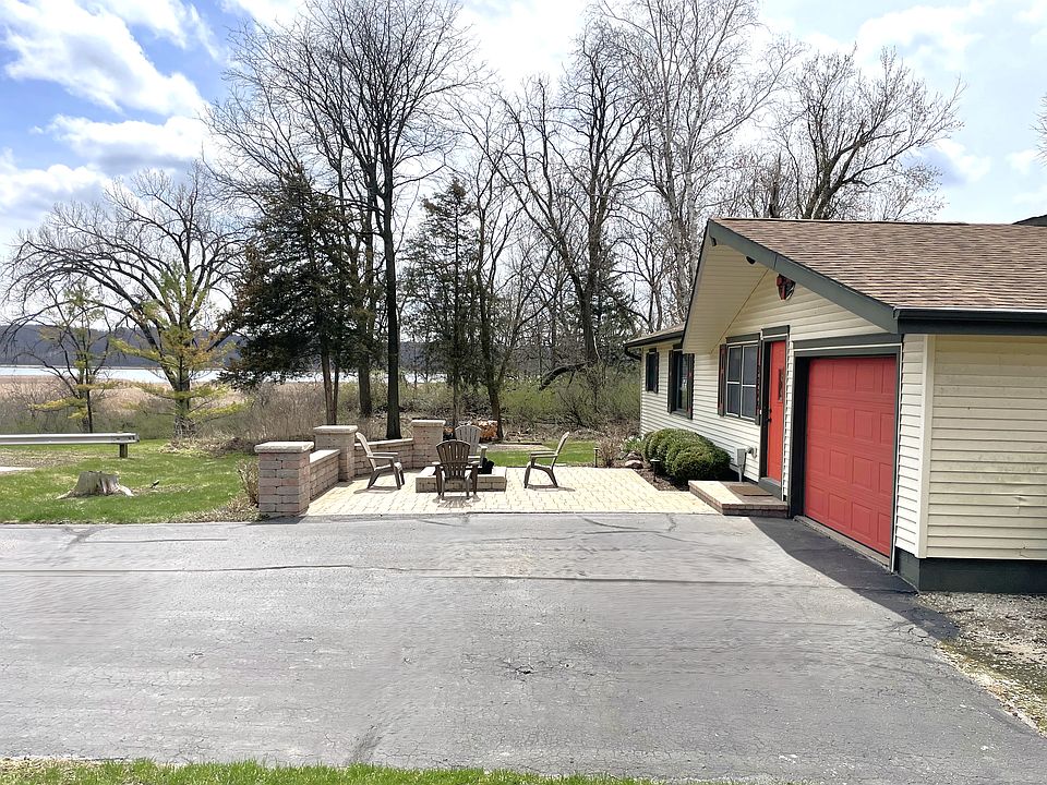 The home's exterior and nice size yard with a built-in stone firepit and lake views.