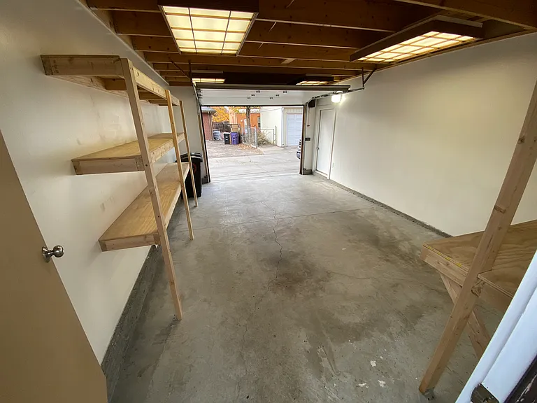 One car garage with storage and workbench.