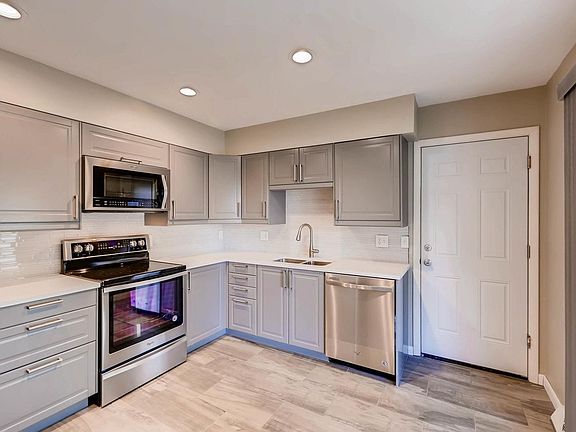 Kitchen with new stainless steel appliances and garage access.