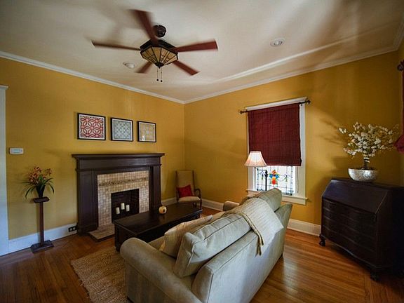 Cozy living room features original coal fireplace, recessed lighting and warm original oak floors