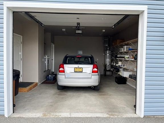 The single car garage is oversized with shelving on the right.