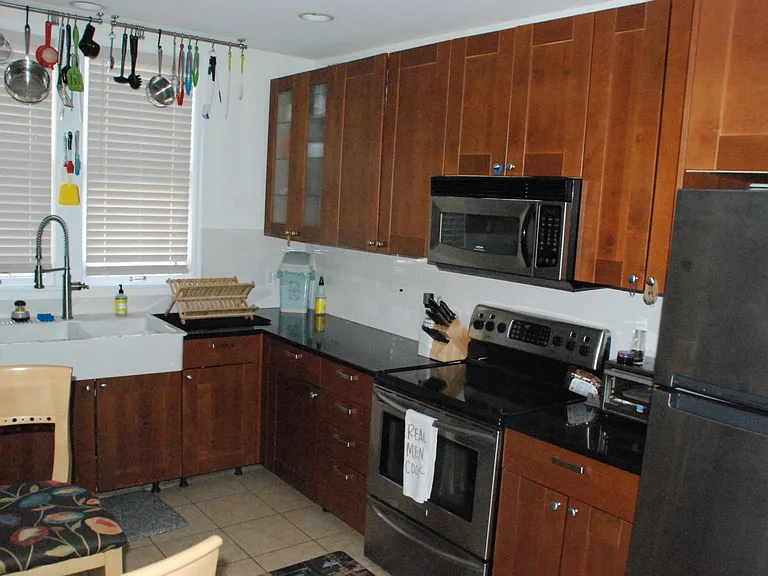 Lower cabinets to left of fridge and right of sink have easy access via dual built in sliding baskets in each. Lower cabinet north of stove extends to back wall, and has dual rotating trays which makes access to "pots/pans in back" much easier.