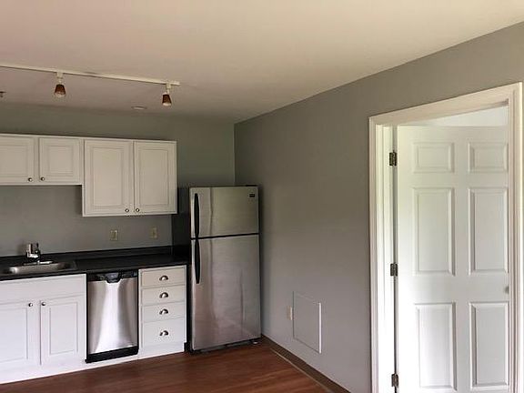 Kitchen area from living area with back bedroom entrance.