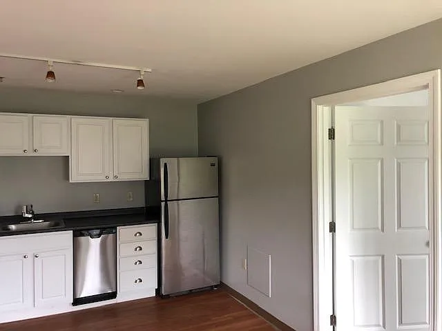 Kitchen area from living area with back bedroom entrance.