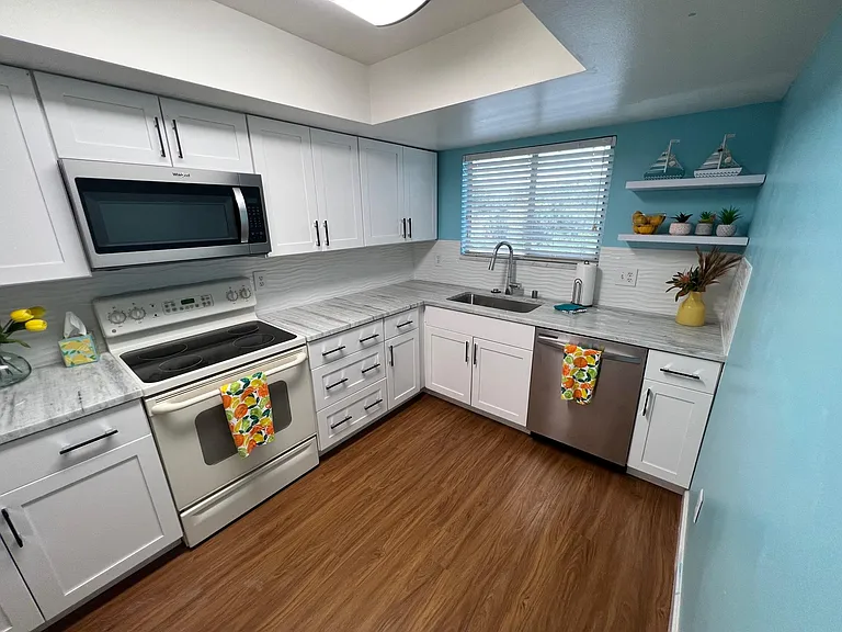 Granite countertops with new dishwasher, new microwave and white cabinets