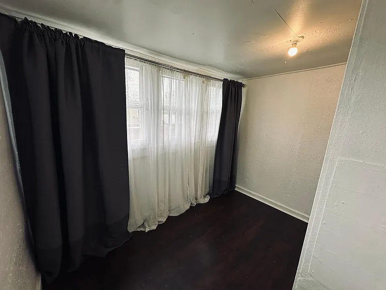 Bedroom, black out curtains and sheer curtains provided, light filled room. Laminate wood floors. 
East facing window.