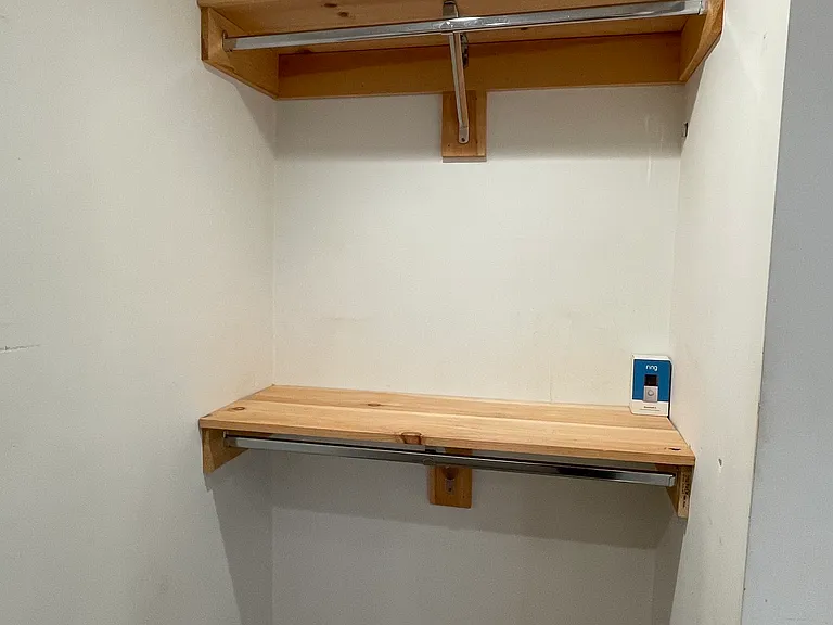 Primary suite walk-in closet with built-in shelving for extra storage.