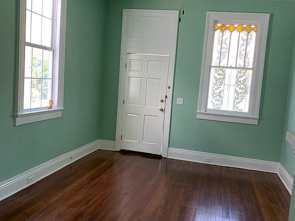 View of front parlour looking at front door. Original stained glass window.